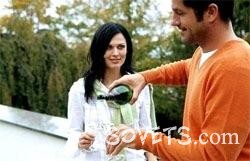 Девушка с парнем пьют вино на улице